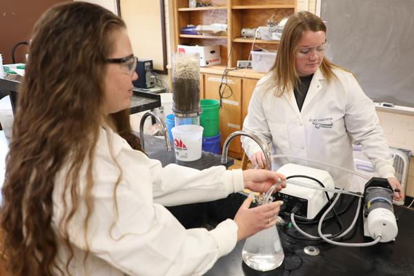 Two female students using equipment in a lab